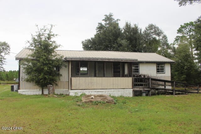 view of front facade with a front lawn and central AC