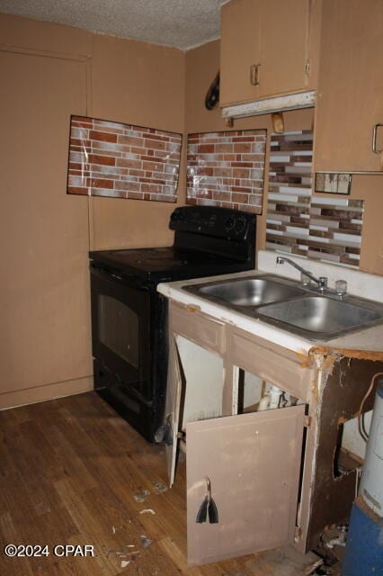 kitchen featuring dark wood-type flooring, a textured ceiling, black electric range oven, and sink