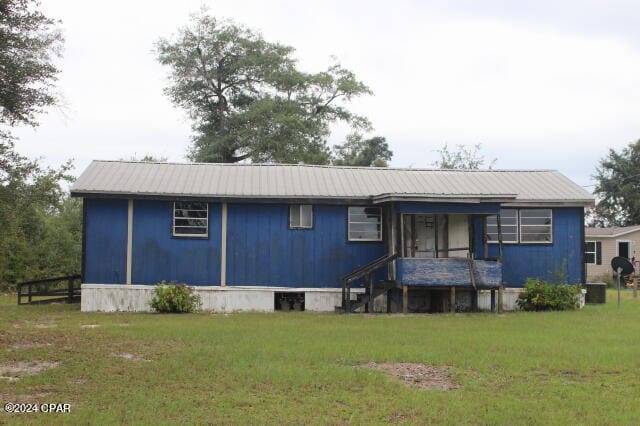 back of property featuring a lawn