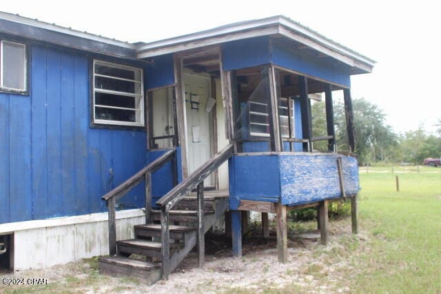 doorway to property featuring a yard