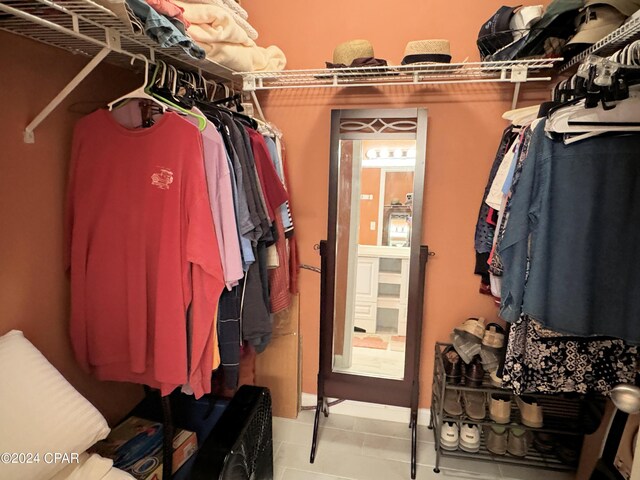 spacious closet with light tile patterned floors