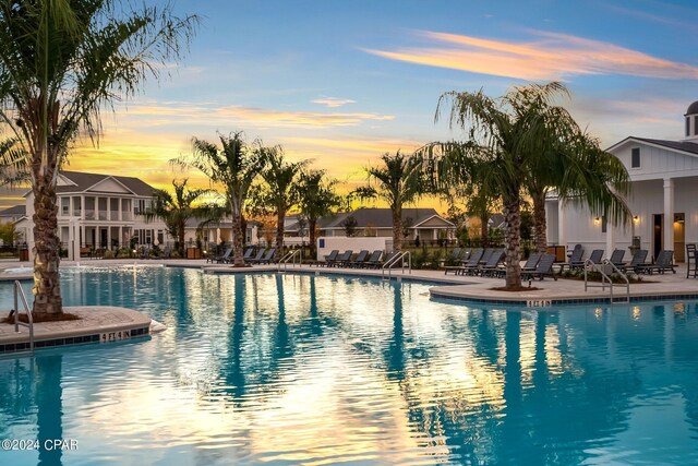 pool at dusk featuring a patio