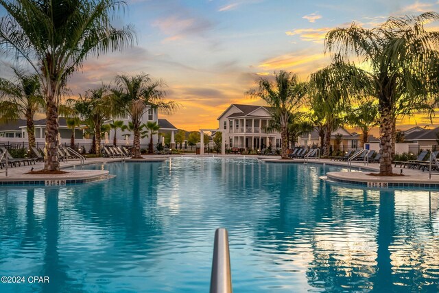 pool at dusk with a patio area