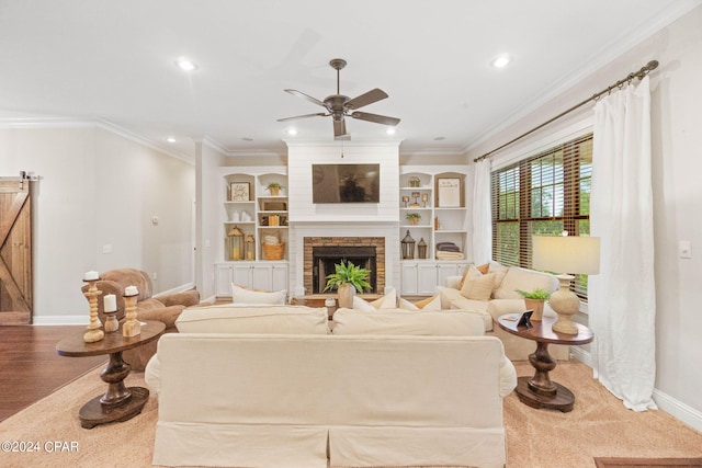 living room with a fireplace, crown molding, hardwood / wood-style floors, and ceiling fan