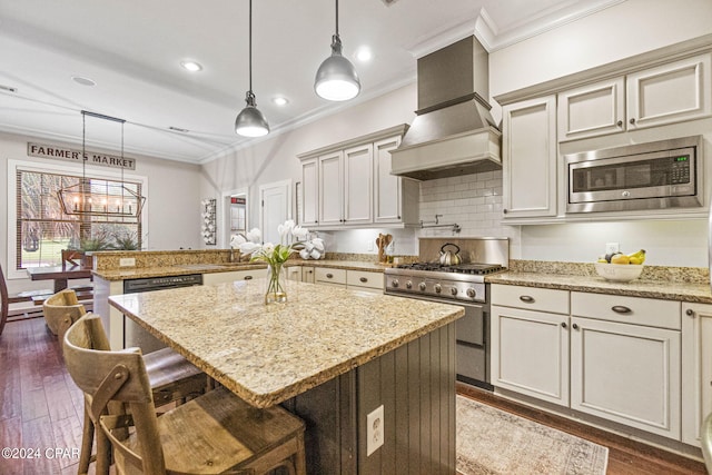 kitchen with a center island, appliances with stainless steel finishes, custom exhaust hood, dark hardwood / wood-style floors, and pendant lighting