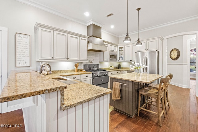 kitchen with a breakfast bar area, decorative light fixtures, dark hardwood / wood-style flooring, stainless steel appliances, and custom exhaust hood