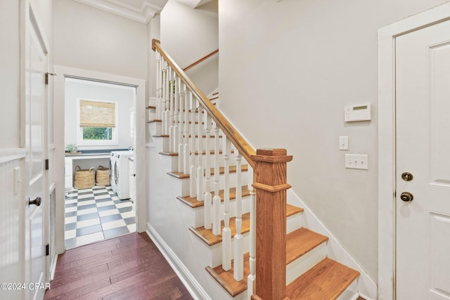 stairs featuring washing machine and clothes dryer and hardwood / wood-style flooring