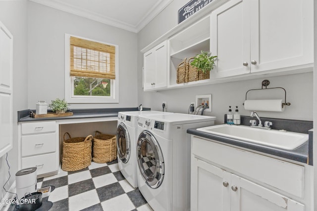 clothes washing area with ornamental molding, cabinets, washer and dryer, and sink