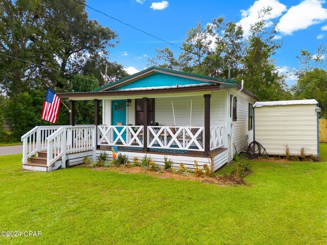 view of front facade with a storage unit, a porch, and a front yard