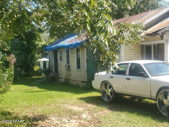 view of property exterior featuring a lawn and cooling unit