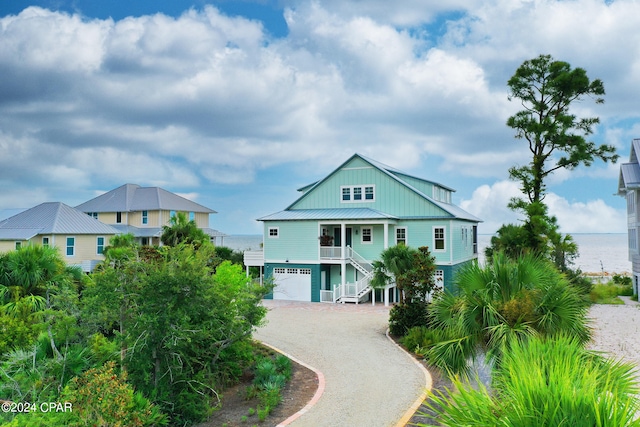 raised beach house featuring a garage and a water view