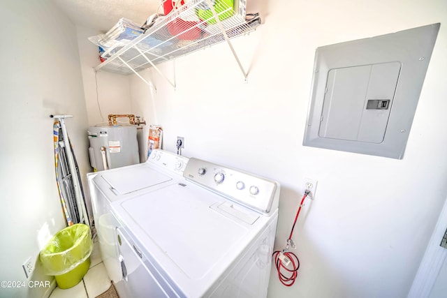 clothes washing area featuring electric panel, water heater, and washer and clothes dryer