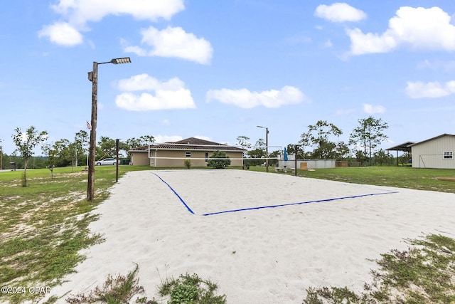 view of property's community with a lawn and volleyball court