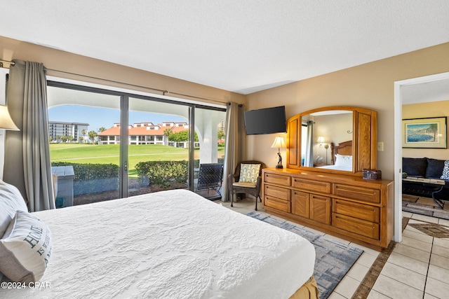 tiled bedroom with a textured ceiling and access to exterior