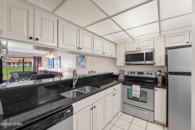 kitchen with white cabinetry, stainless steel appliances, sink, and light tile patterned floors