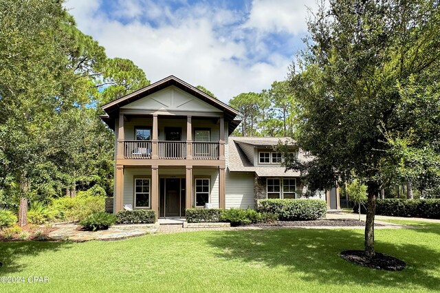 view of front facade with a balcony and a front lawn