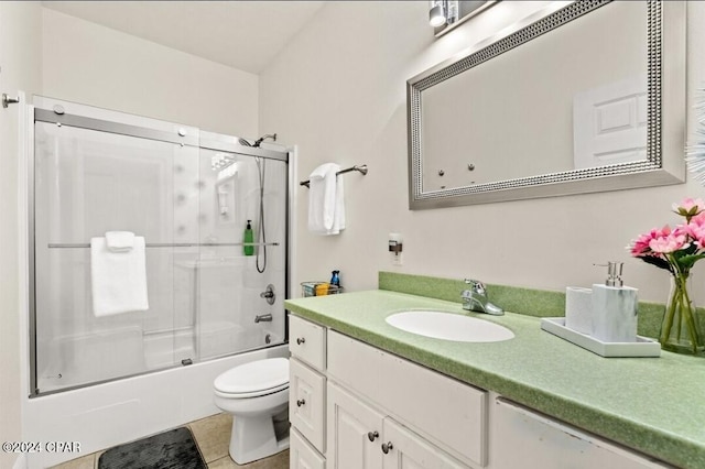 full bathroom featuring toilet, bath / shower combo with glass door, vanity, and tile patterned floors