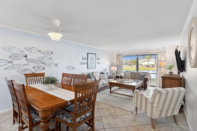 tiled dining area with ceiling fan and ornamental molding