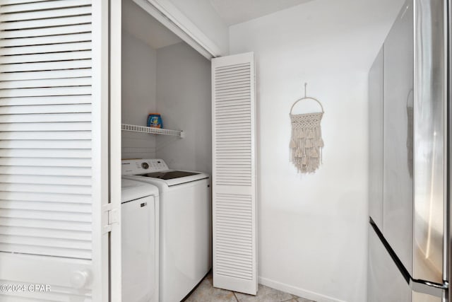 laundry room featuring washing machine and dryer and light tile patterned flooring