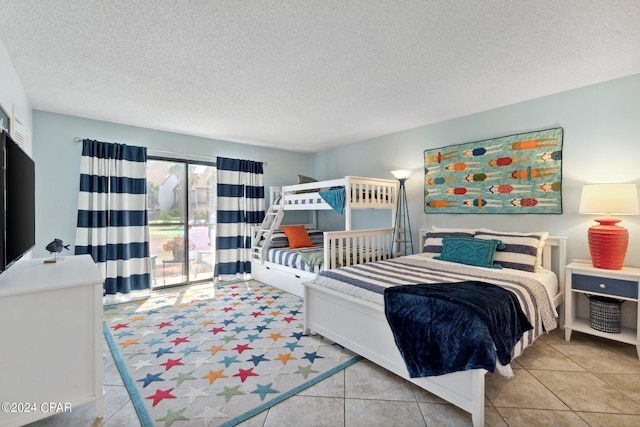 tiled bedroom with a textured ceiling and access to outside