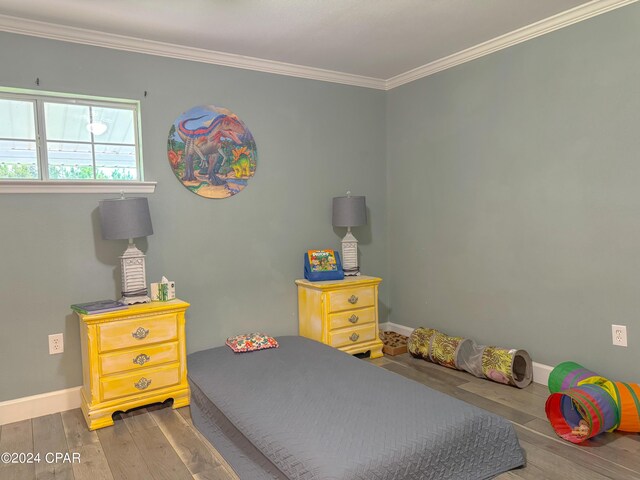 bedroom with ornamental molding and dark hardwood / wood-style floors