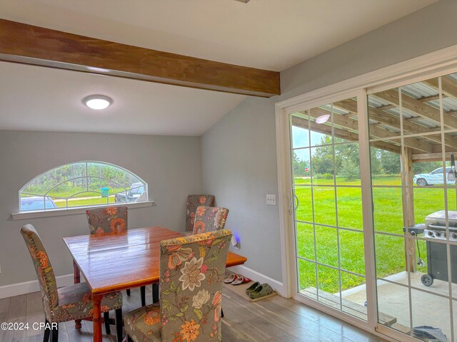 dining area with hardwood / wood-style flooring, lofted ceiling with beams, and a wealth of natural light