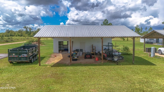 back of house with a lawn and an outbuilding