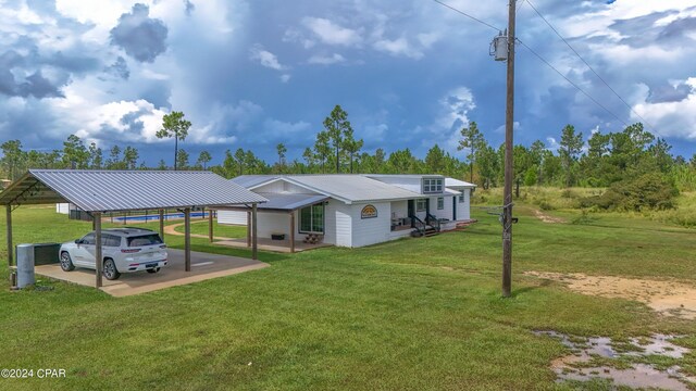 rear view of property with a yard and a carport