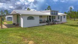 rear view of house with a yard and a patio