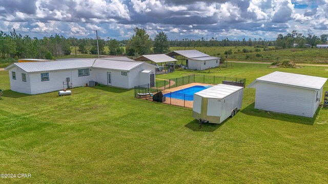 exterior space with cooling unit, a storage shed, and a yard