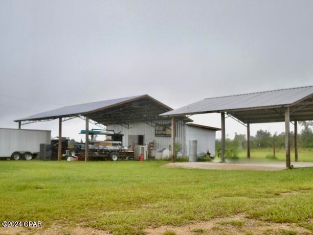 back of property with a lawn and a carport