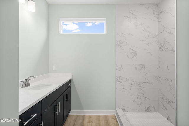 bathroom featuring vanity, hardwood / wood-style flooring, and a tile shower