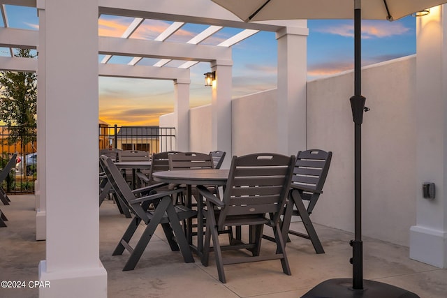 patio terrace at dusk featuring a pergola