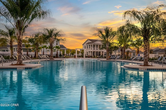 pool at dusk with a patio area