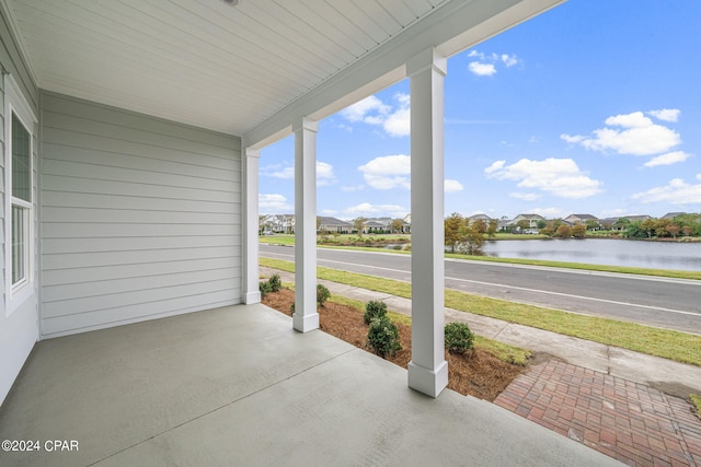 view of patio with a water view and a porch