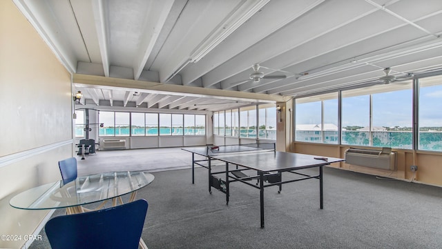 sunroom with beam ceiling, a water view, and ceiling fan