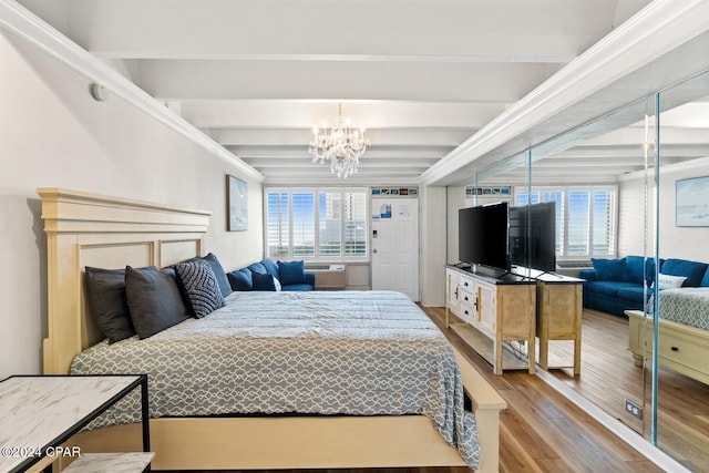 bedroom with wood-type flooring, beamed ceiling, a notable chandelier, and multiple windows