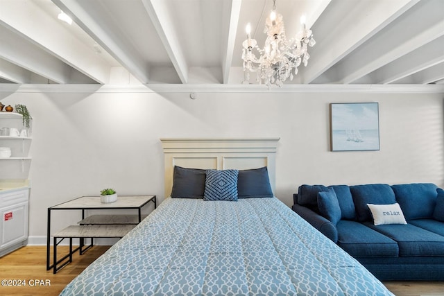 bedroom featuring a notable chandelier, beam ceiling, and hardwood / wood-style floors