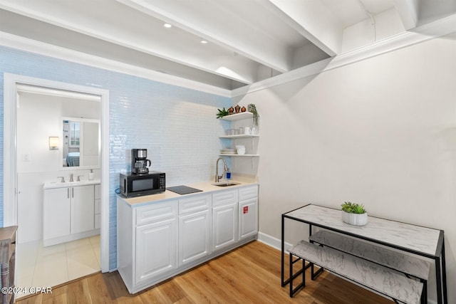 kitchen featuring sink, light hardwood / wood-style flooring, and white cabinets