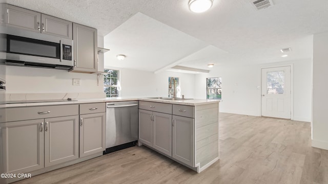 kitchen featuring gray cabinetry, light hardwood / wood-style floors, kitchen peninsula, stainless steel appliances, and a textured ceiling