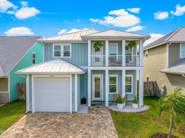 view of front facade featuring a balcony, a garage, and a front lawn