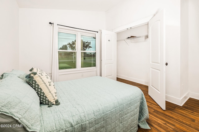 bedroom with lofted ceiling, dark hardwood / wood-style floors, and a closet