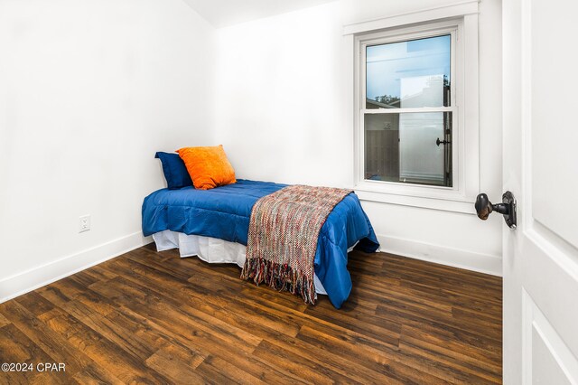 bedroom with dark hardwood / wood-style floors