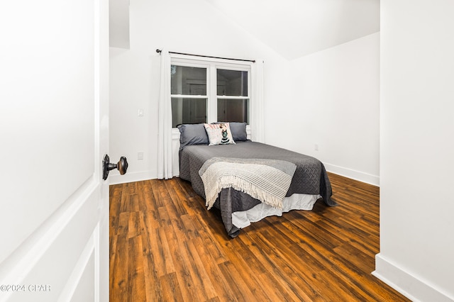 bedroom with dark hardwood / wood-style flooring and vaulted ceiling