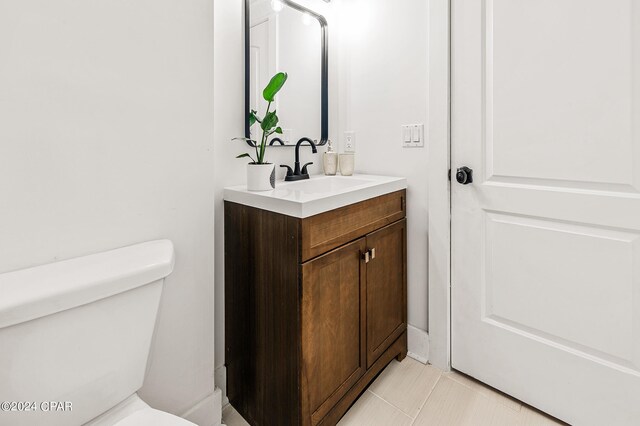 bathroom featuring toilet, vanity, and tile patterned flooring