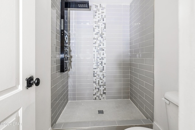 bathroom with toilet and tiled shower