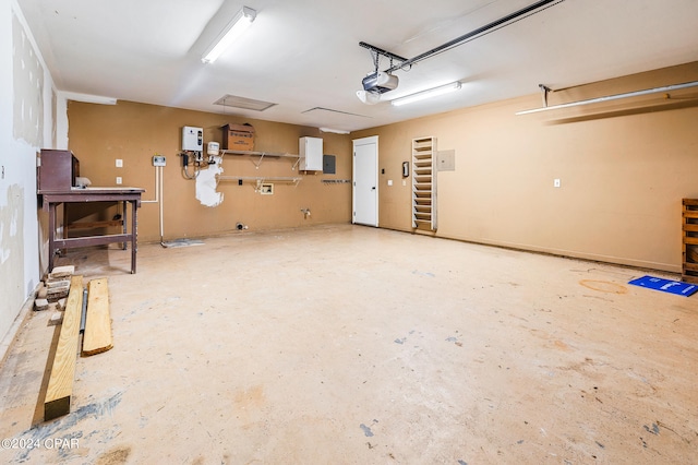 garage featuring a workshop area, electric panel, and a garage door opener