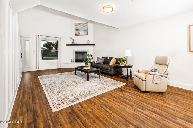 living room featuring dark wood-type flooring, lofted ceiling, and a high end fireplace