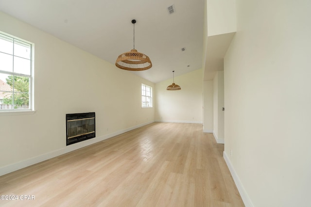 unfurnished living room featuring high vaulted ceiling, light wood-type flooring, and heating unit