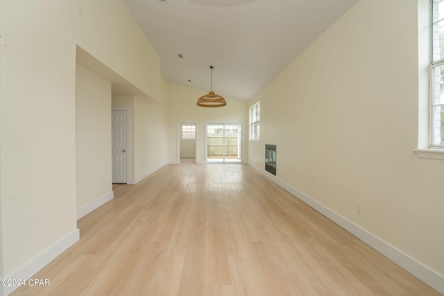 unfurnished room with light hardwood / wood-style flooring, heating unit, and plenty of natural light